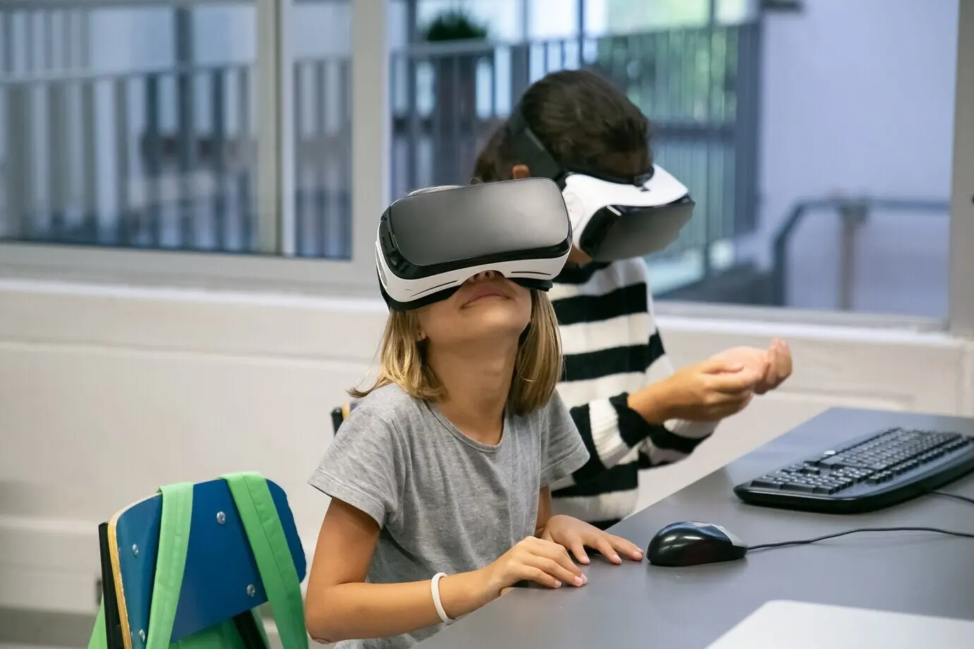 Porträt kleiner Kinder, die VR-Headsets benutzen und Spaß haben.
