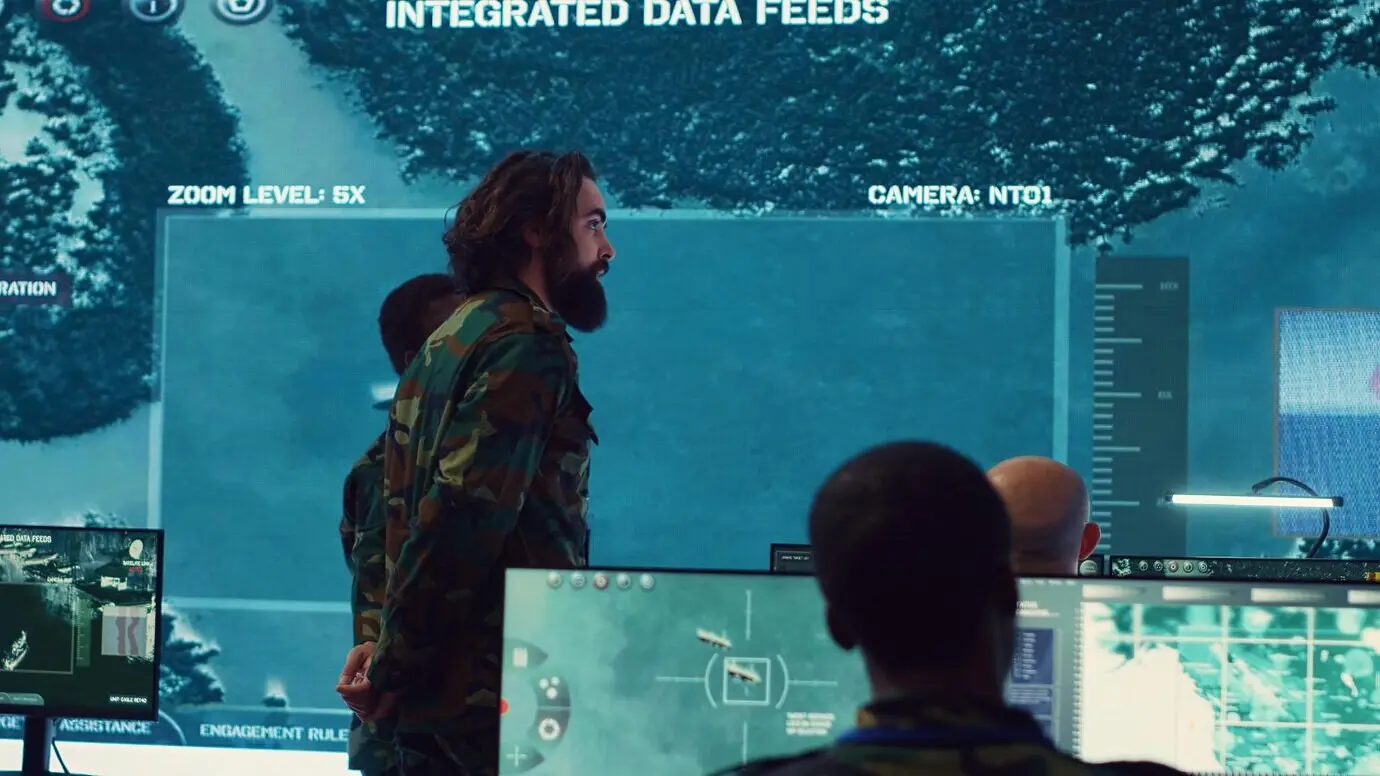 Militärische Überwachungsoffiziere sprechen neben einem großen Bildschirm im Generalhauptquartier.
