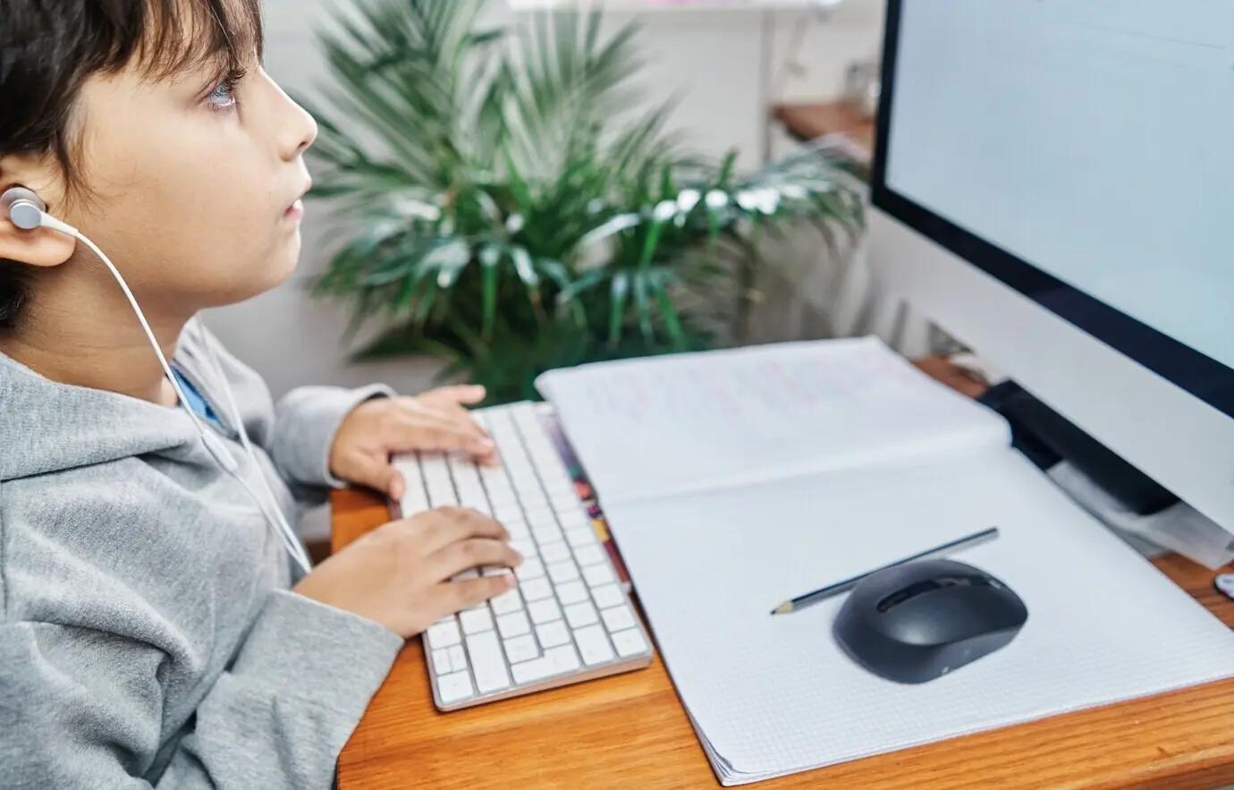 Kaukasischer Junge, der wegen COVID-19 über eine Videokonferenz von zu Hause aus lernt – Homeschooling.